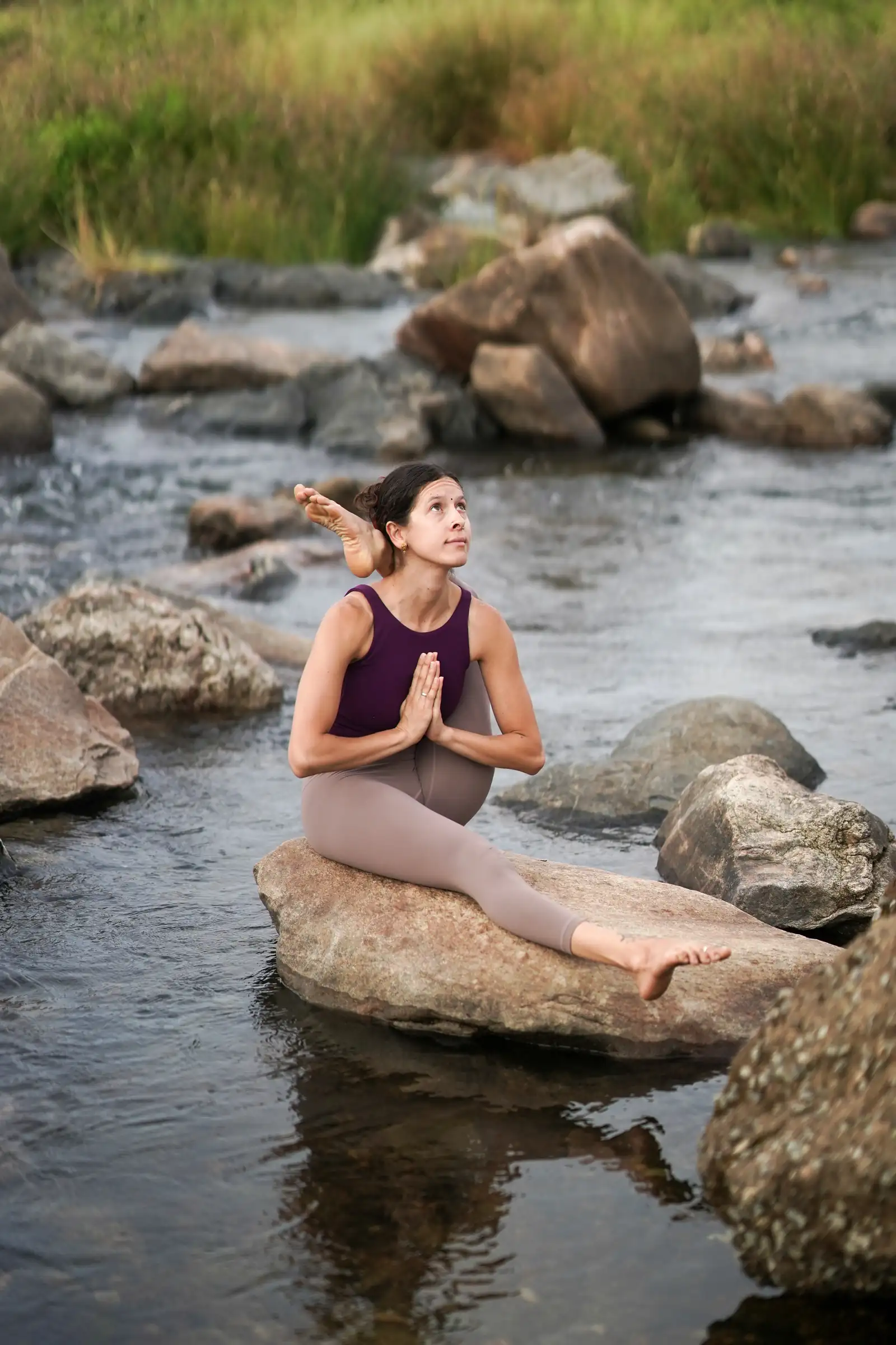 Cecilia Cambre, Ashtanga and Mysore teacher, in a seated posture on a river rock