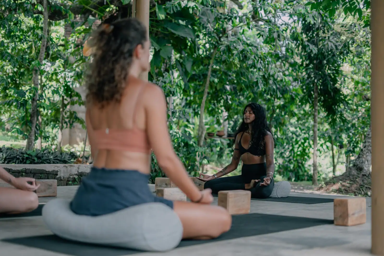 Practitioners sitting on mats in the open-air shala at Senses