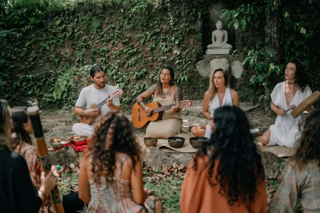 Musicians with guitar and singing bowls at an open-air gathering in the garden at Senses Sri Lanka