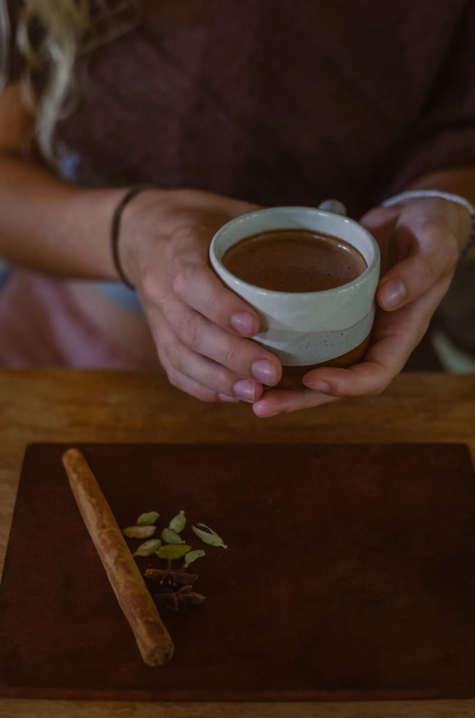 A cup of spiced cacao held in two hands at Flow Café, Weligama