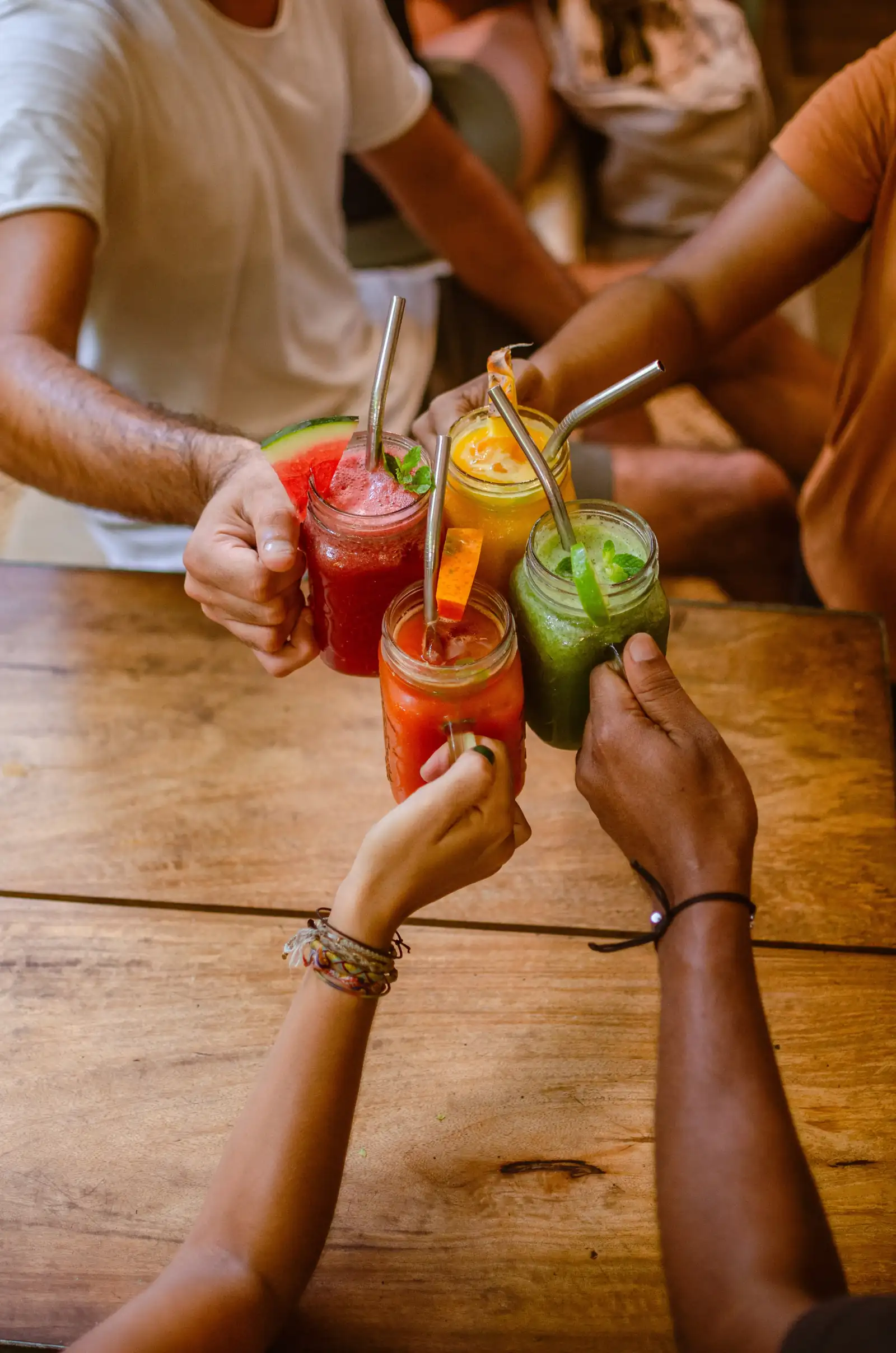 Fresh juices and smoothies in jars raised in a toast at Flow Café, Weligama