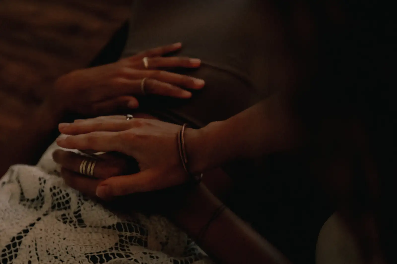 Close-up of two hands resting on a person's chest during a breathwork session at Senses