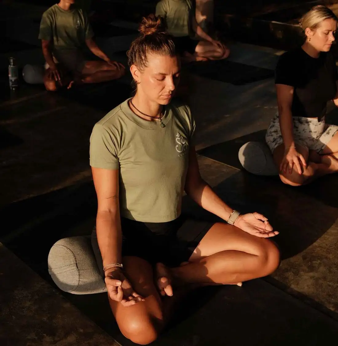 A student sitting cross-legged in meditation in the shala at Senses